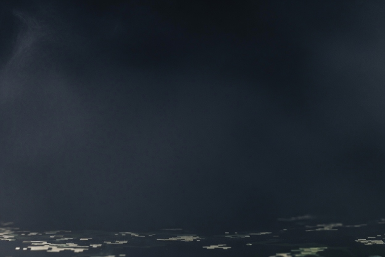 Dark tactical CQB background with drifting smoke and low-light camouflage texture for QuietBlast Tactical